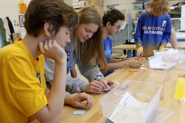 Several students work on patterns and storyboards for their finger puppets